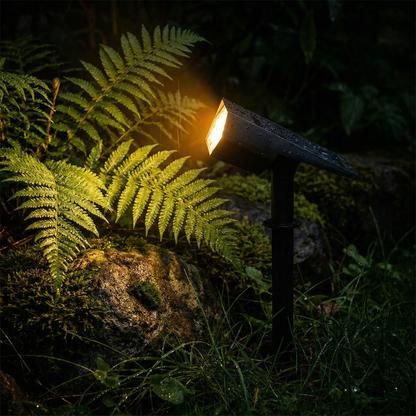 Solar spotlight in flower bed at dusk